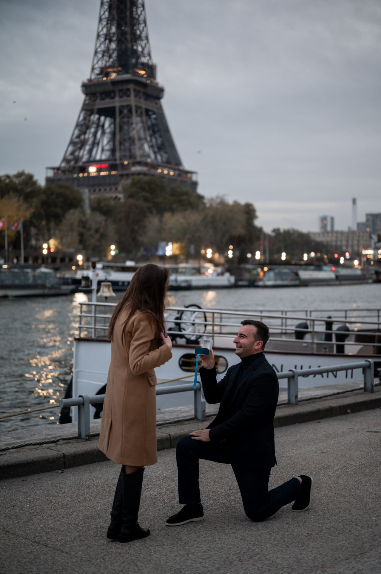 homme s'agenouille pour demande en mariage devant Tour Eiffel