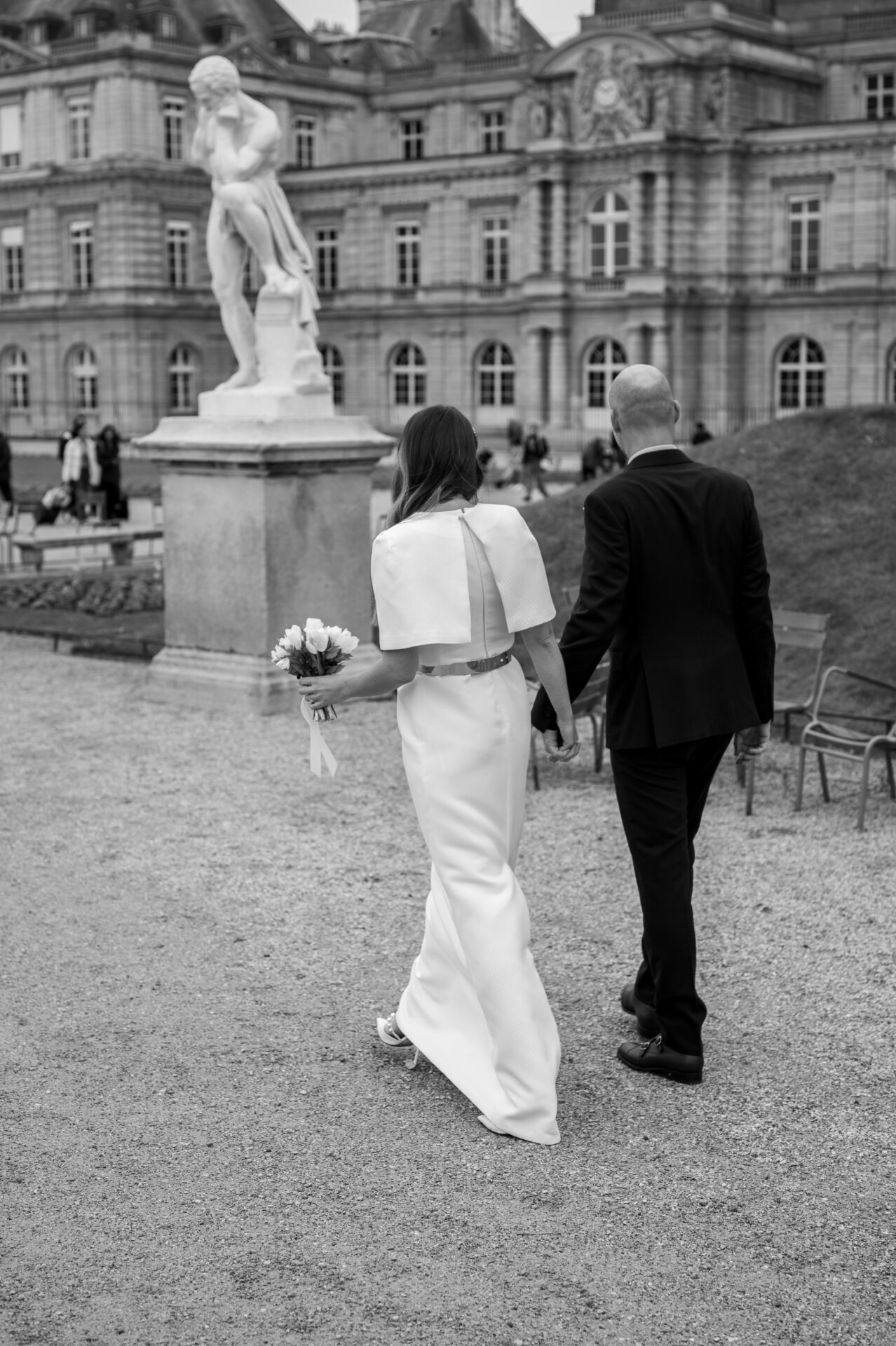 couple marié de dos marche dans le jardin du Luxembourg