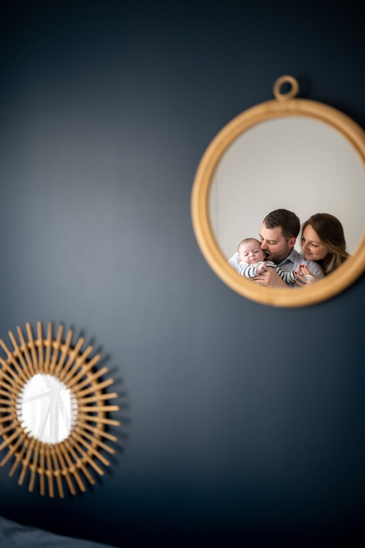 photo miroir d'une famille composée de parents qui tiennent leur enfant