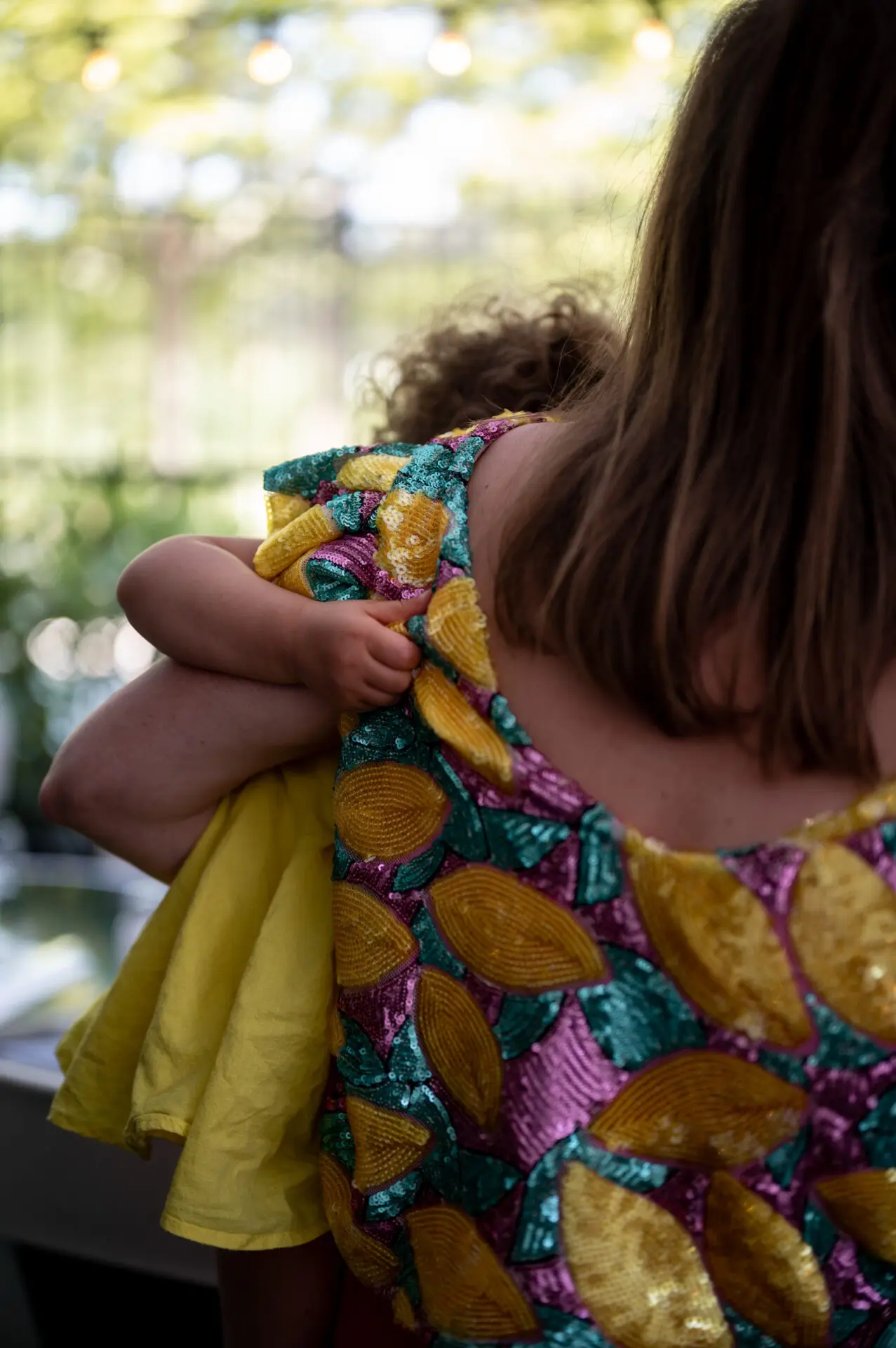 un bébé tient sa maman par le t-shirt