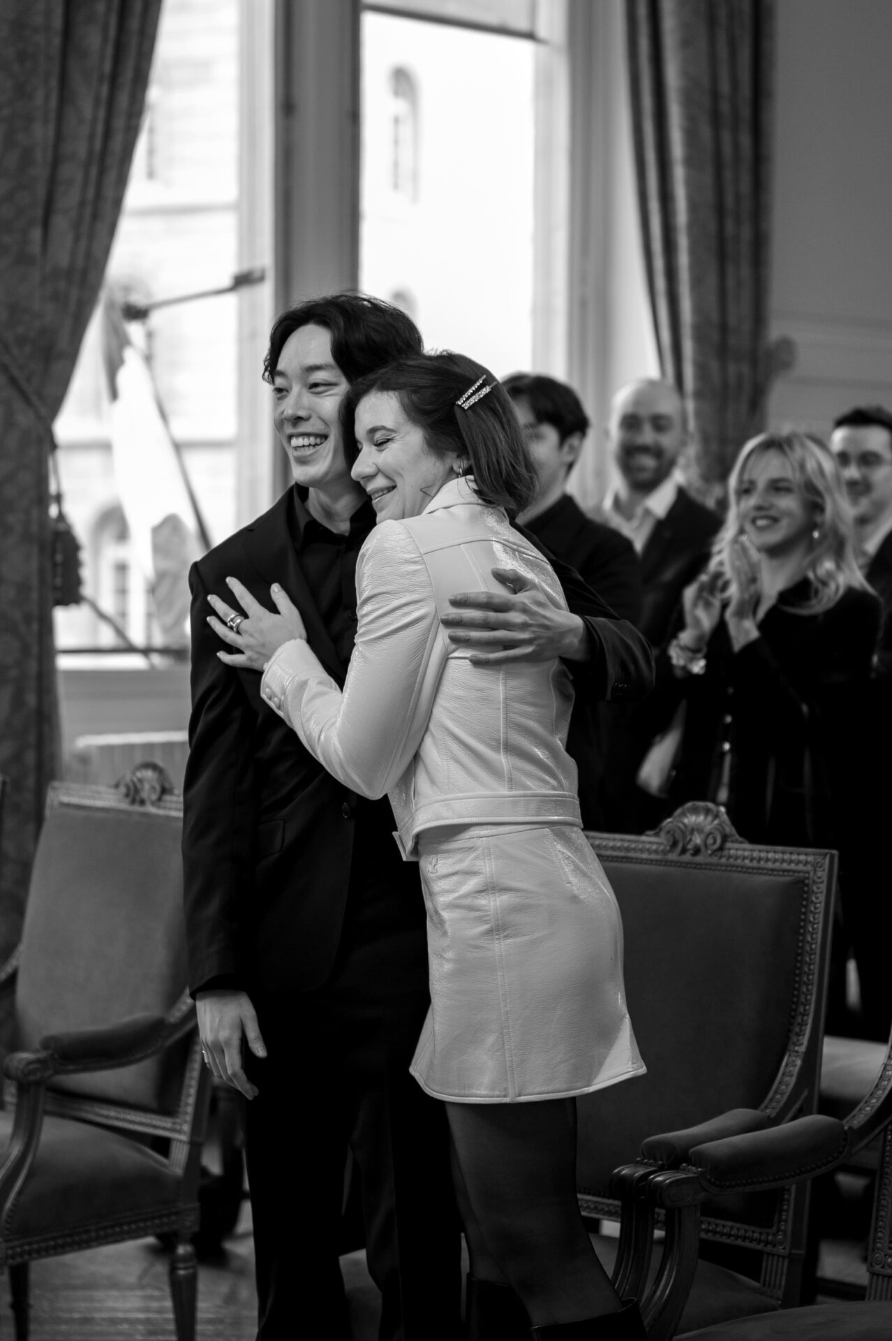 couple de jeunes mariés s'enlacent à la mairie parisienne