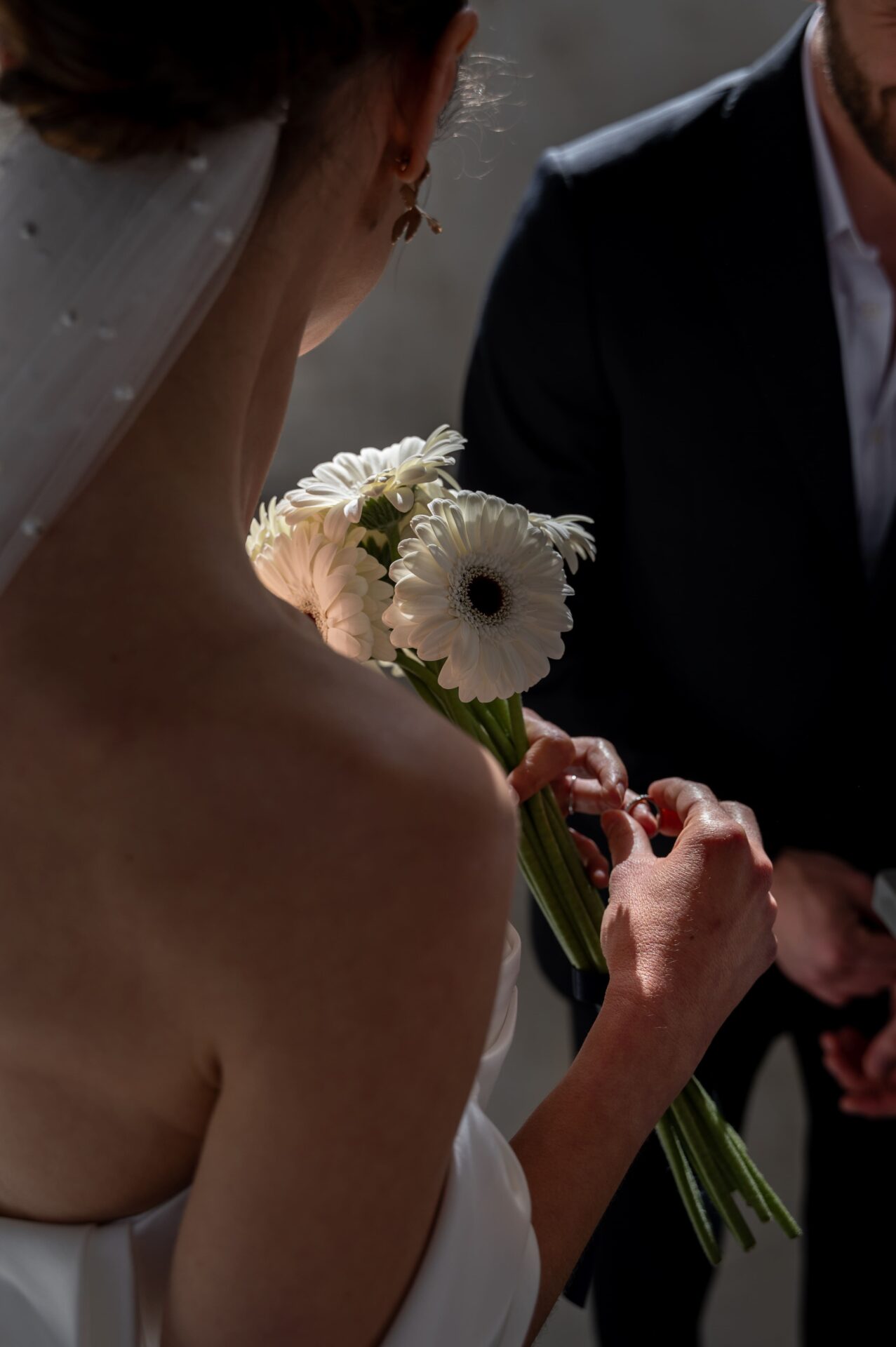 jeune mariée joue avec sa bague tout en tenant son bouquet de fleurs