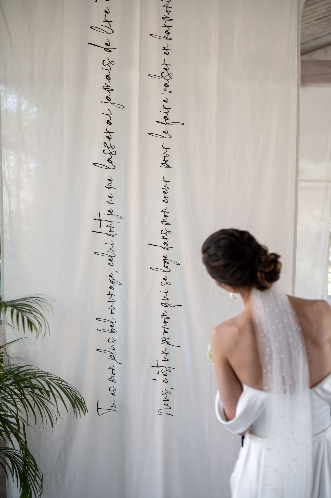 mariée lit les voeux écrits pour son mariage sur un rideau