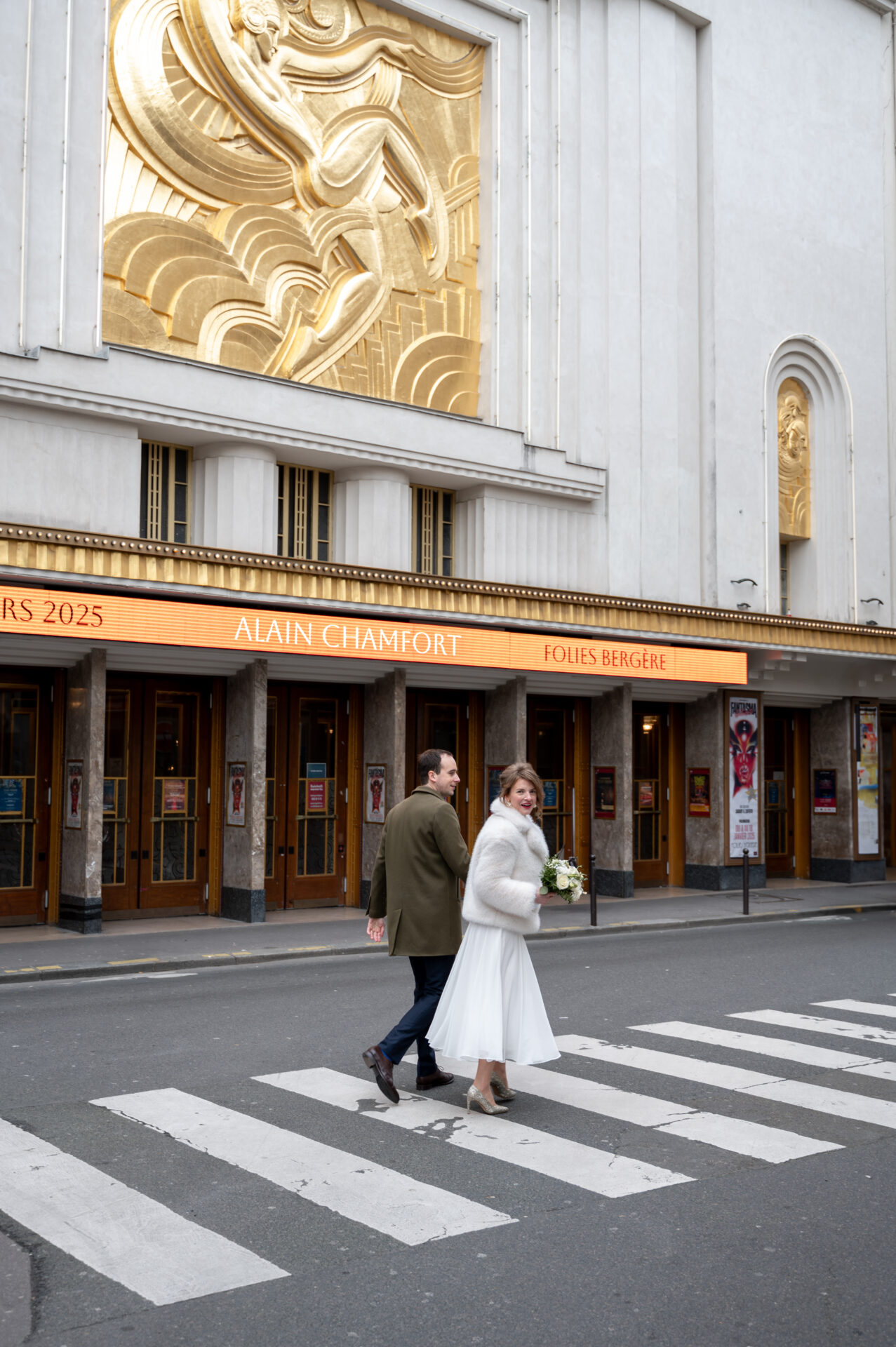 couple walking in front of folies bergères paris 