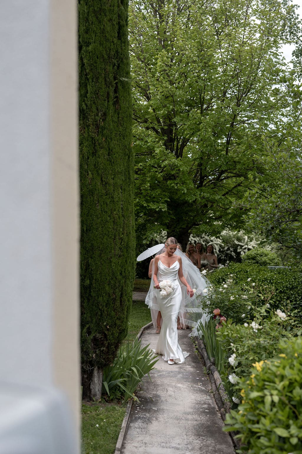 bride walking following by her bridesmaids