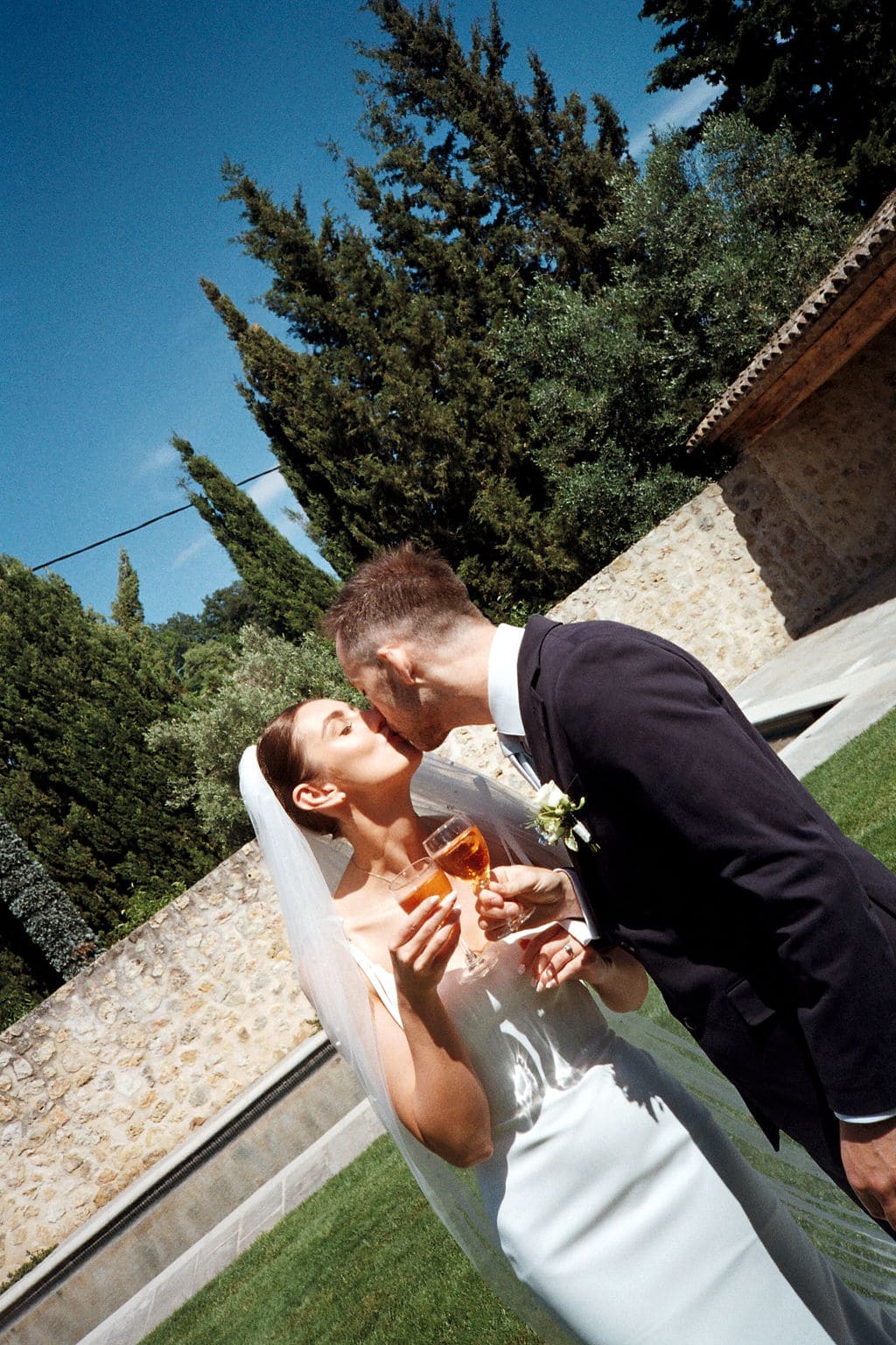 Rachel & Nick's wedding, French Riviera, May 2025 bride and groom kissing with spritz in their hands