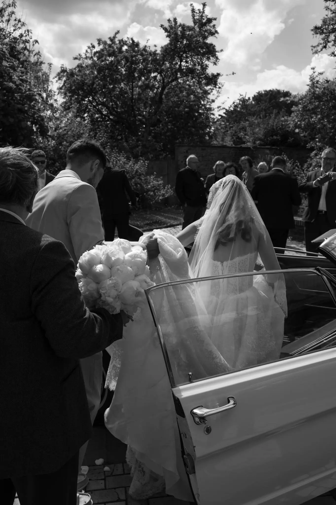 mariée monte en voiture en contre-jour